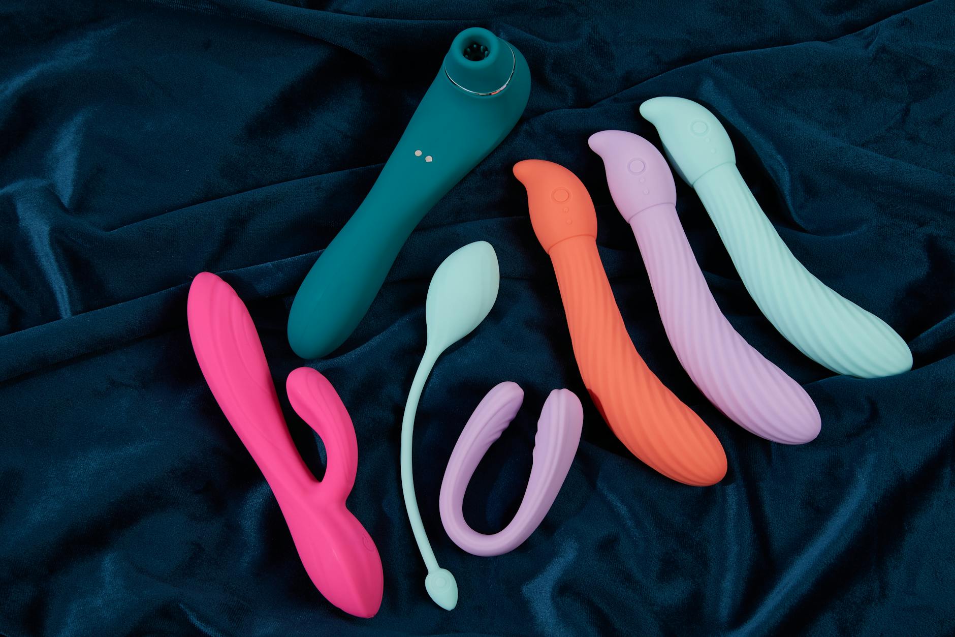 A basket of colorful vibrators and a pink flower representing intimacy tools for couples