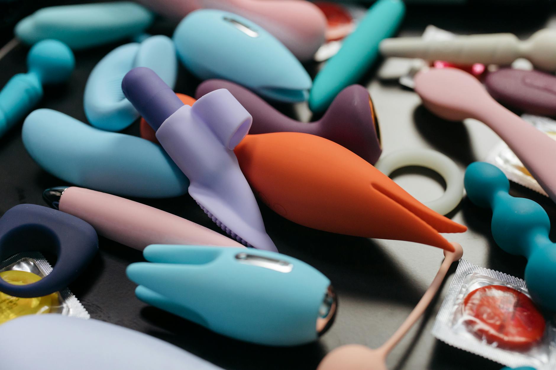A hand holding a vibrator against a purple backdrop, representing modern self-pleasure without shame
