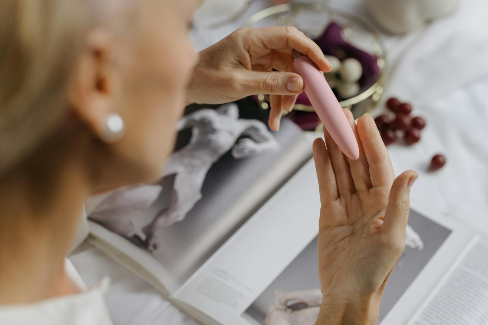 Woman holding personal massagers with thoughtful expression