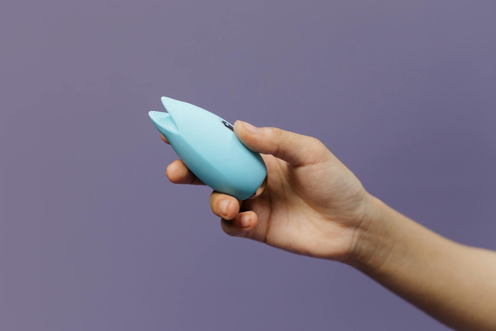 Lemon clitoral vibrator held in hand, showing suction technology for partnered intimate moments